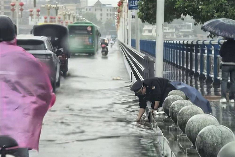 桥头积水十厘米，怀化一城管队员徒手疏通桥头排水口被网友抓拍