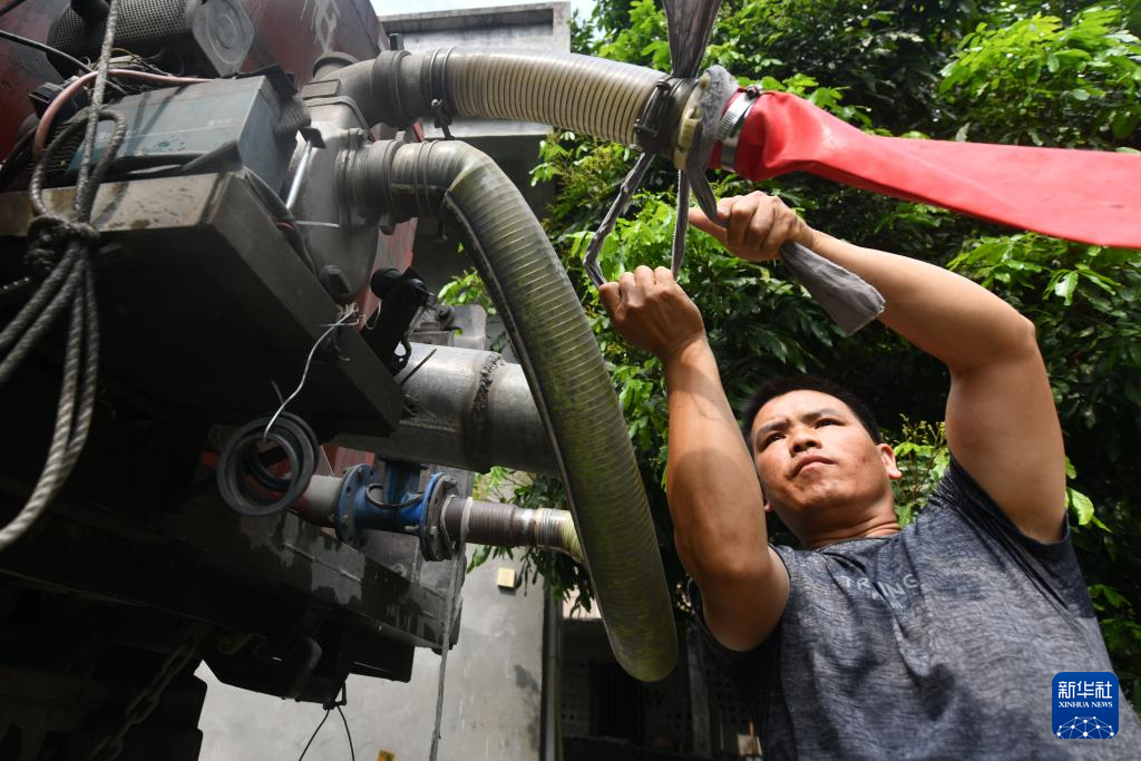 4月21日,在广西马山县里当瑶族乡北屏村,送水人员将水从运水车引入水柜。新华社记者 黄孝邦 摄