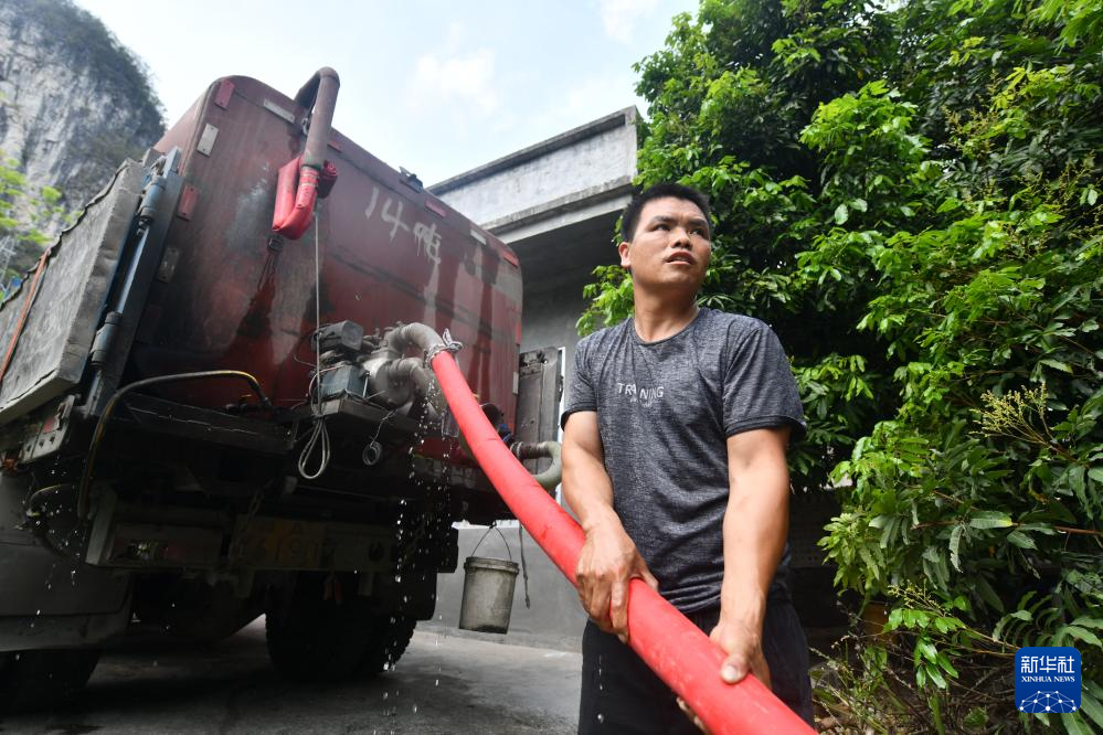 4月21日,在广西马山县里当瑶族乡北屏村,送水人员将水从运水车引入水柜。新华社记者 黄孝邦 摄